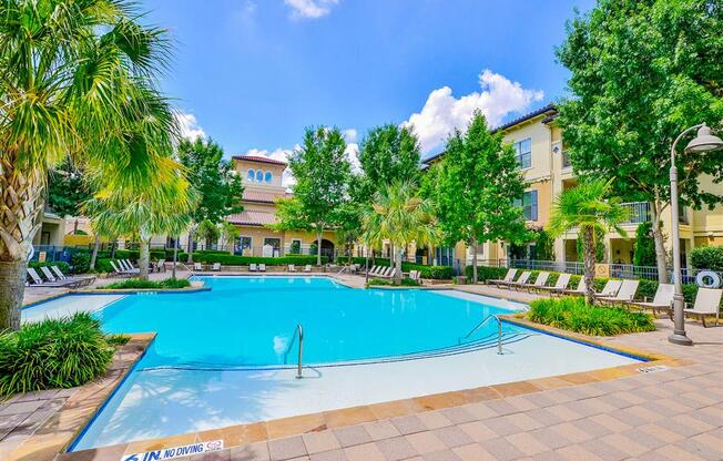 Sparkling pool with lounge chairs at Mission at La Villita Apartments in Irving, TX offers 1, 2 & 3 bedroom apartment homes with appliances.