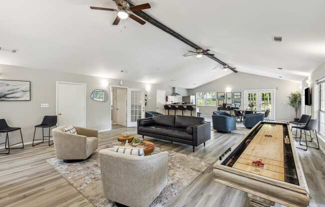 a living room with couches and chairs and a shuffleboard table