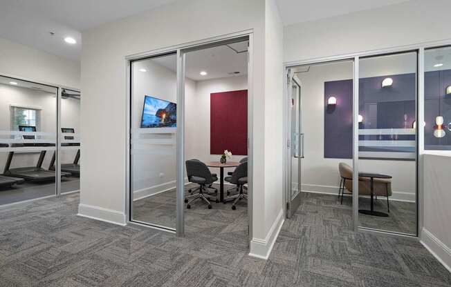 A conference room with a grey carpet and a red wall.