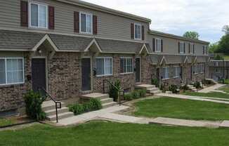 exterior of townhomes with green grass and concrete sidwalks