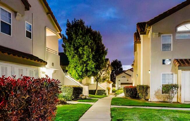 A residential street with houses and a sidewalk.