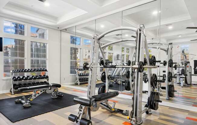 a home gym with weights and cardio equipment and windows