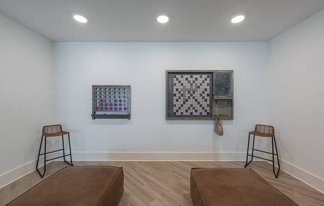 a living room with two stools and two pieces of art on the wall