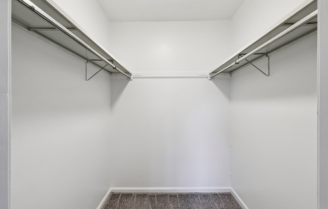 A white hallway with a carpeted floor and two metal rails on the wall.