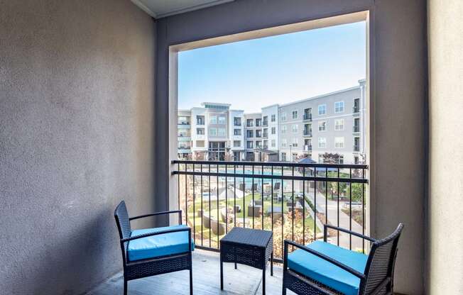 Carillon Apartments in Nashville, TN 37219 photo of a balcony with two chairs and a table and a large window