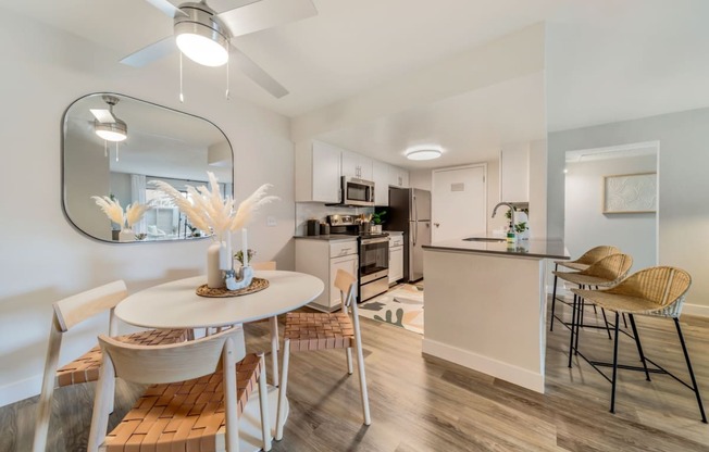 a dining area with a table and chairs and a kitchen in the background  at Citrine Hills, Ontario, CA, 91761