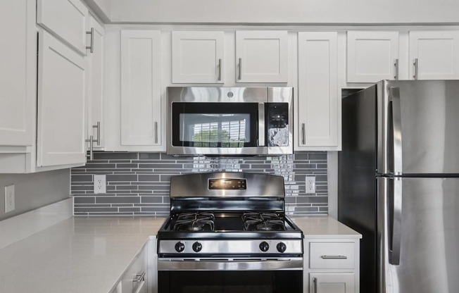 A modern kitchen with a stove and refrigerator.