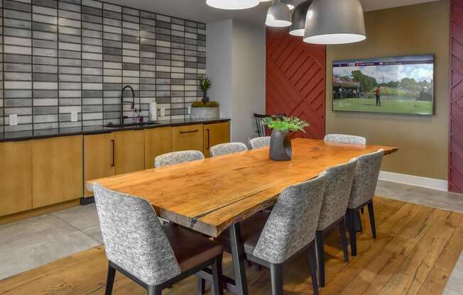 A modern dining room with a wooden table and grey chairs.