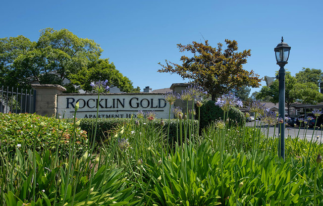 A sign for Rocklin Gold Apartment Homes is surrounded by greenery at Rocklin Gold Apartments, California, 95677