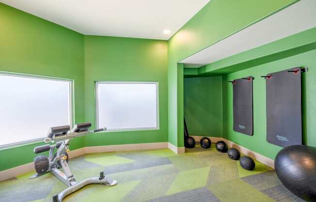 a gym with green walls and exercise equipment