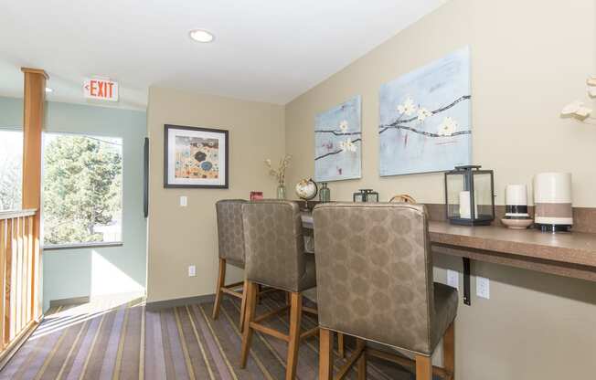 a dining area with two chairs and a bar with a counter and a window