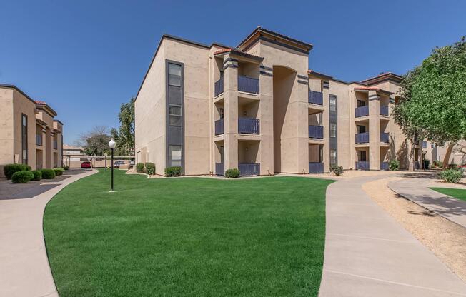 a large brick building with green grass