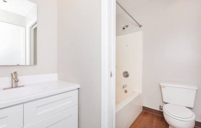 a bathroom with a toilet sink and tub and a mirror