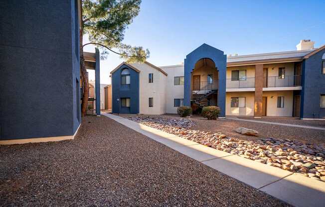 A row of modern houses with a gravel driveway in between.