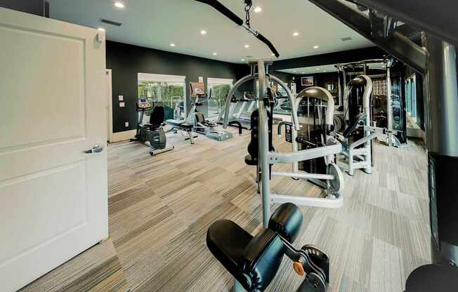 A gym with a variety of equipment including weights and cardio machines.