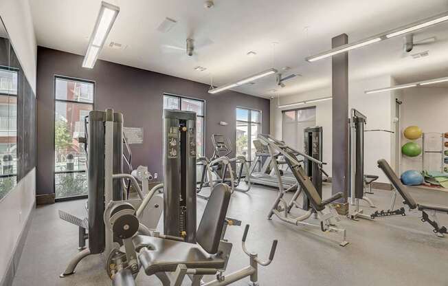 A gym with a variety of equipment including weights and exercise balls at Infinity on the Point Apartments, Texas, 75243