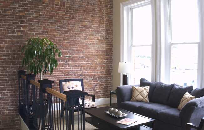 a living room with a brick wall and a couch and a table