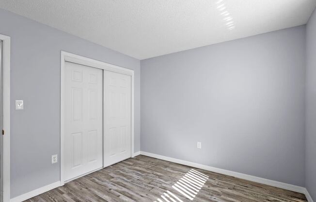an empty room with a white door and grey walls