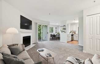 A living room with a grey couch and a fireplace.