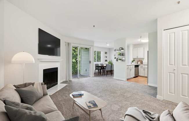 A living room with a grey couch and a fireplace.
