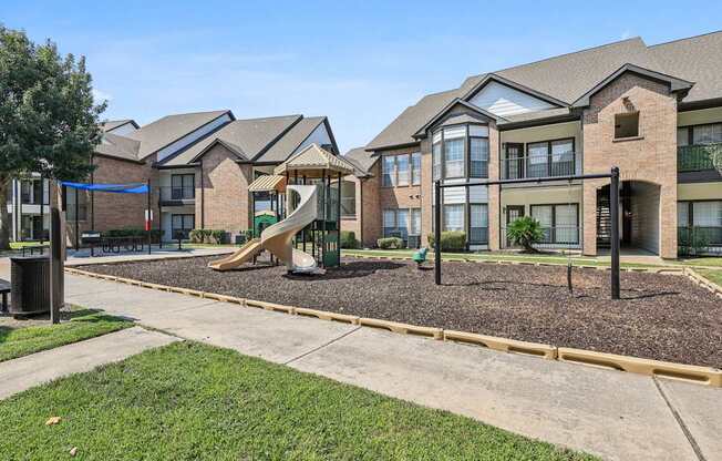 A playground area in front of a row of houses.