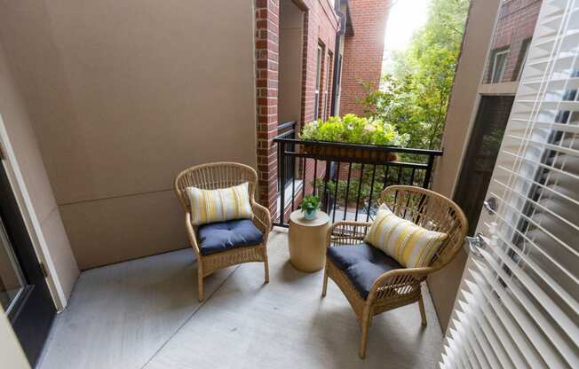 a balcony with two chairs and a table