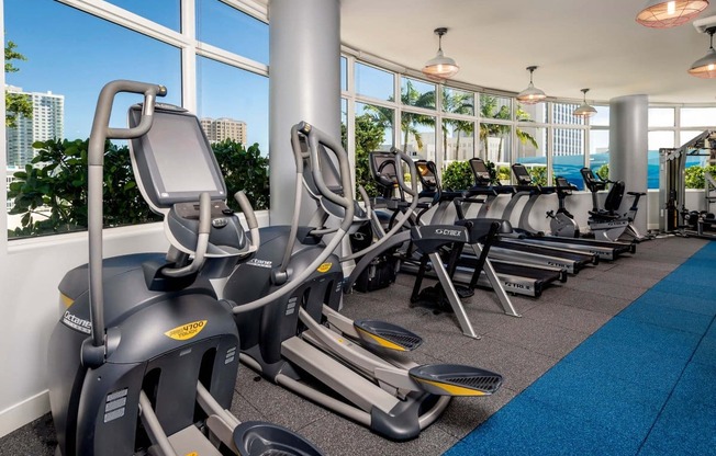 a gym with cardio equipment and a large window with a view of the ocean at Regatta at New River, Fort Lauderdale, FL