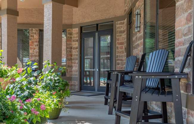 a porch with chairs and a table and a door