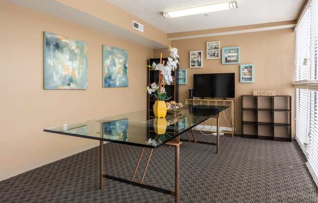 a room with a glass table and a television in the corner