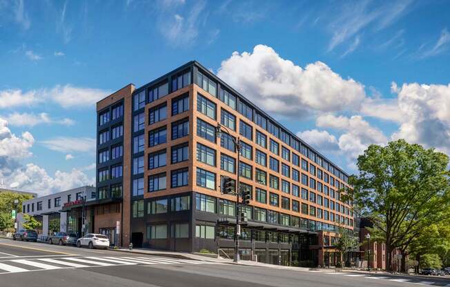 A modern multi-story building with large windows and a flat roof.