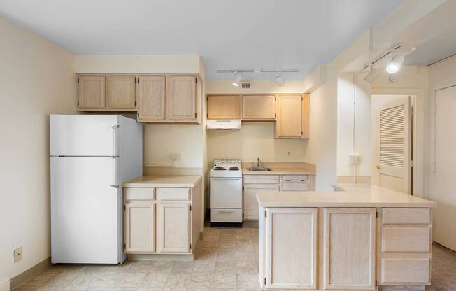 a kitchen with wood cabinets and a refrigerator and a stove