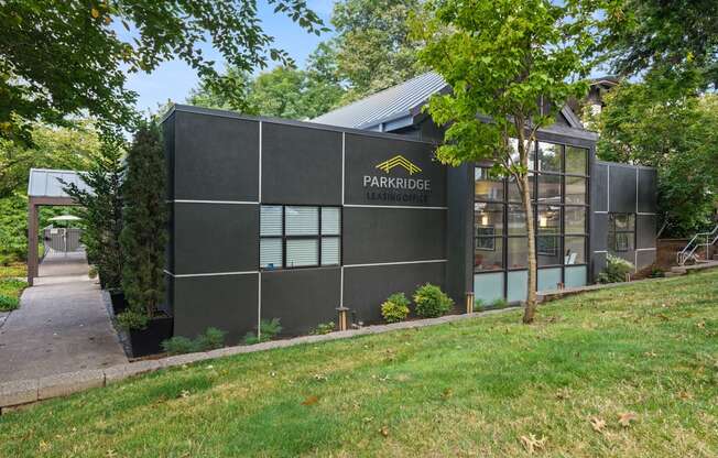 A building with the words "PARKRIDGE" on it is surrounded by trees and grass.