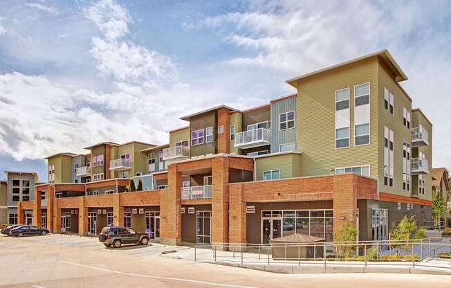 A large multi-story building with a parking lot in front.