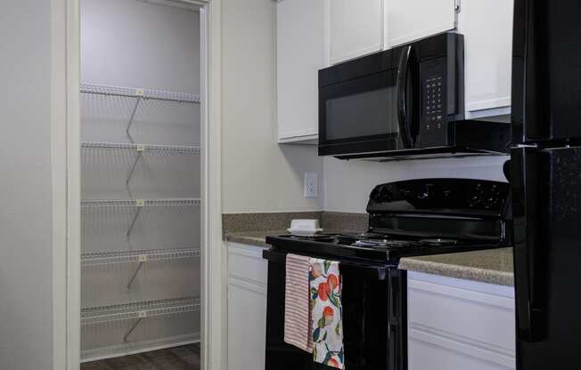 a kitchen with a stove and microwave and a walk in closet