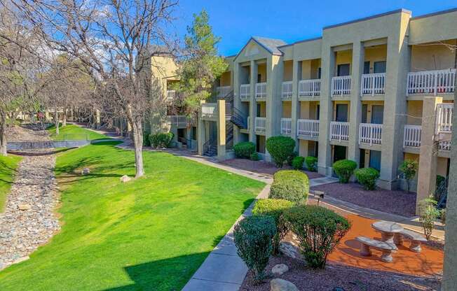 a view of the outside of an apartment building with a yard and grass