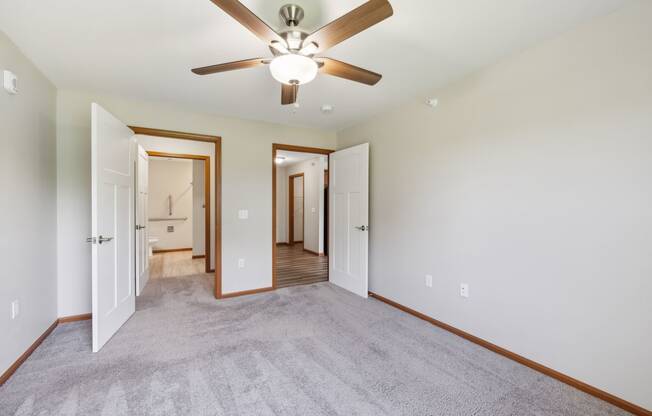 a living room with carpet and a ceiling fan