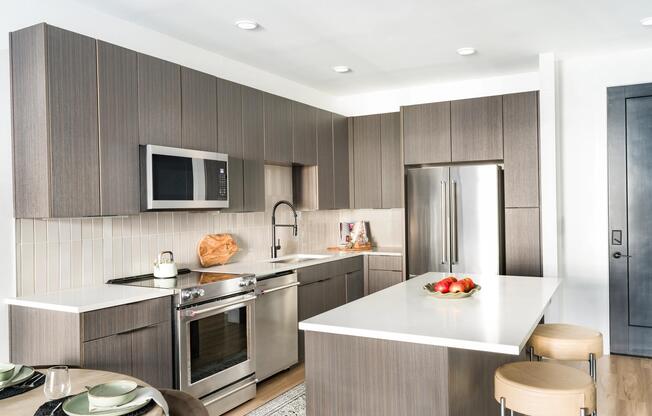 Contemporary kitchen design with rich-toned cabinetry, stainless steel appliances, and a spacious island perfect for cooking or casual dining.