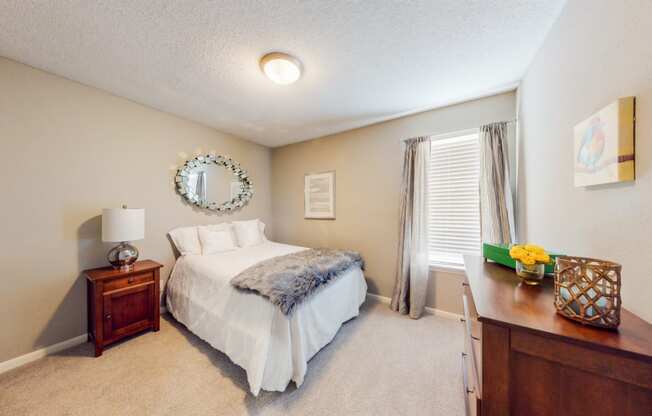 a bedroom with a bed and a dresser and a window
