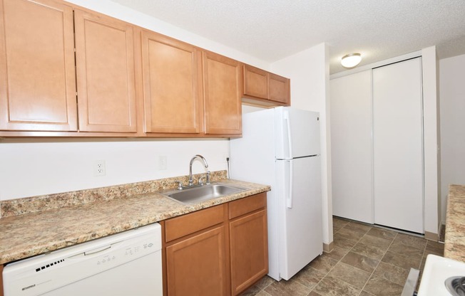 a kitchen with a white refrigerator freezer next to a dishwasher