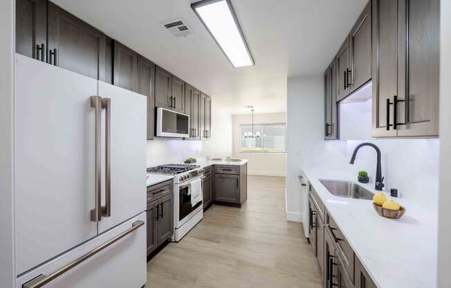 a large kitchen with white appliances and wooden cabinets