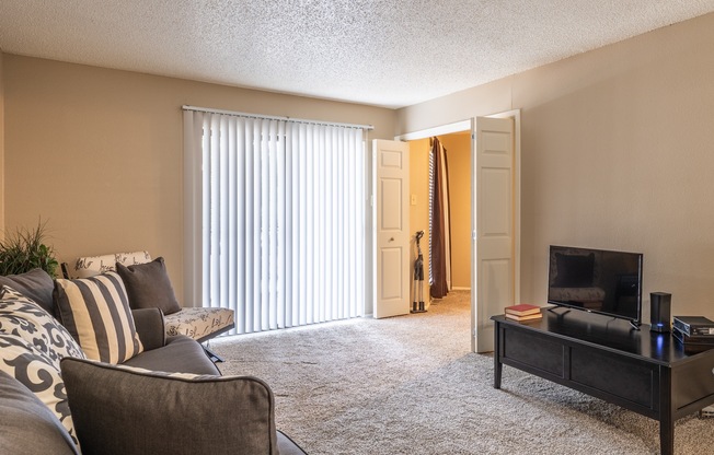 A living room with a grey couch and a black coffee table.