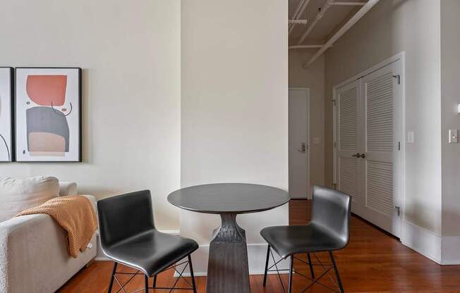 A living room with a grey table and two chairs.