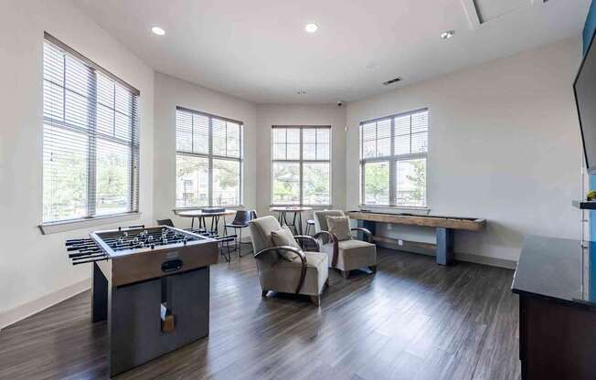 A modern kitchen with a large island and a dining area with chairs.