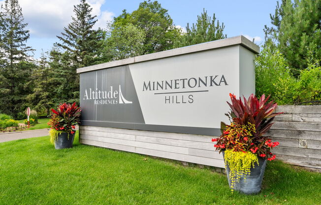 a sign hills at the entrance of a park with flowers