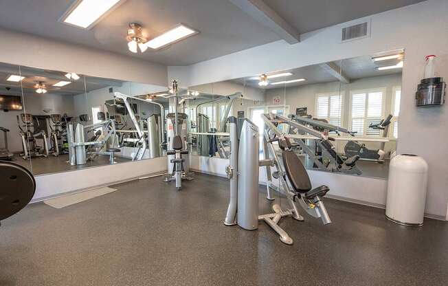 A gym with a variety of equipment including a treadmill, weights, and a bench press at Autumn Oaks Apartments, Roseville, CA, 95678