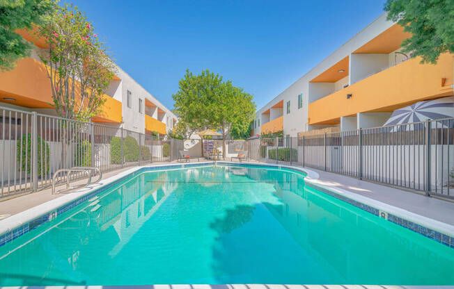 a swimming pool in front of an apartment building with a pool at The Flats on Addison, California, 91423