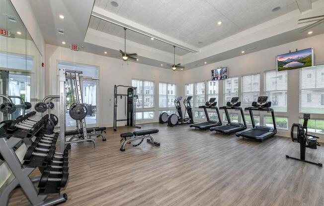 Premium fitness center with cardio equipment, free weights, and weight machines at The Station at Brighton apartments for rent in Grovetown, GA