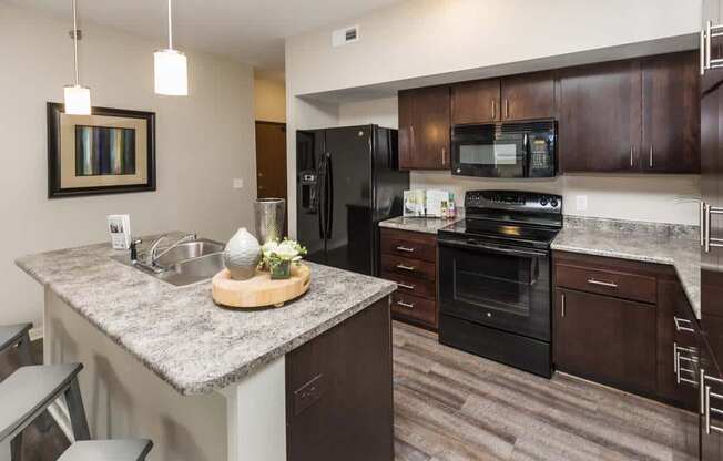 a kitchen with black appliances and a granite counter top