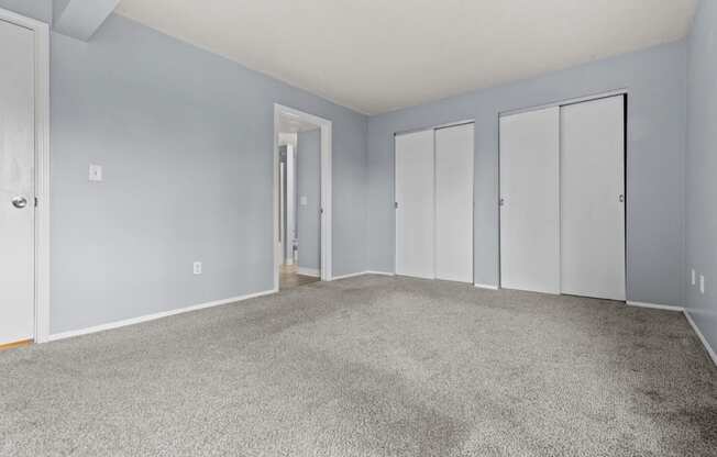 an empty living room with carpet and blue walls