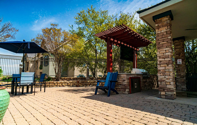 a patio with a pergola and a table and chairs